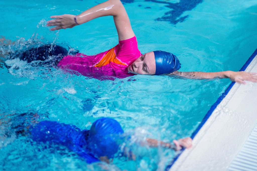 Swimming lesson. Cute little boy learning to swim with swimming
